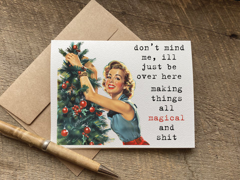 funny christmas card with retro housewife graphic that says: don’t mind me, ill just be over here making things all magical and shit