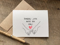 Greeting card with 'happy you and me day' text and heart illustration and two hands with pinkies entwined