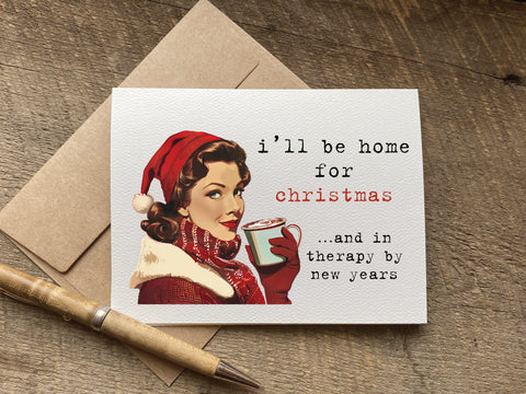 Christmas card with a vintage-style illustration of a woman wearing a Santa hat and holding a mug, with text 'i'll be home for Christmas and in therapy by new years