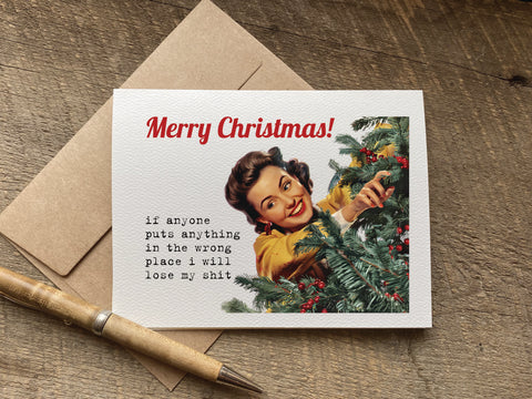 A funny Christmas greeting card with a retro illustration of a woman decorating a tree and the text 'Merry Christmas! if anyone puts anything in the wrong place i will lose my shit', 