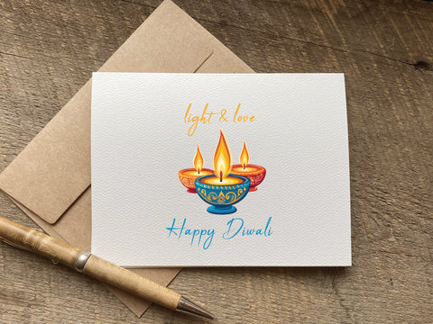 Greeting card with Diwali design featuring lit candles that says light and love happy diwali