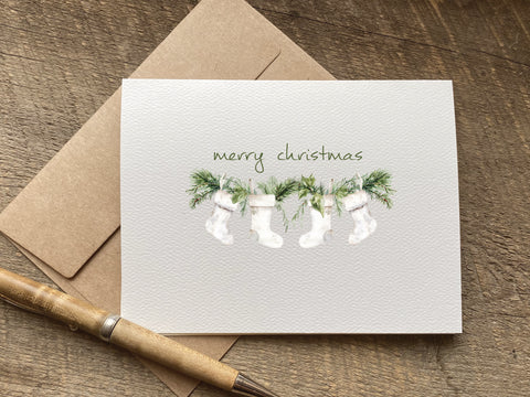 pretty farmhouse rustic christmas card that says "merry christmas" with watercolor stocking garland
