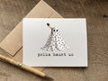 A white halloween greeting card with a black-and-white polka-dotted ghost illustration and the text 'polka haunt us,' 