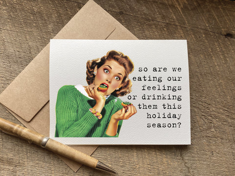 Christmas Greeting card with vintage-style illustration of a woman eating and the text 'so are we eating our feelings or drinking them this holiday season?' 